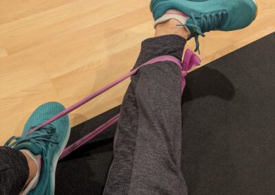 Coach Jennifer stretching legs with bands